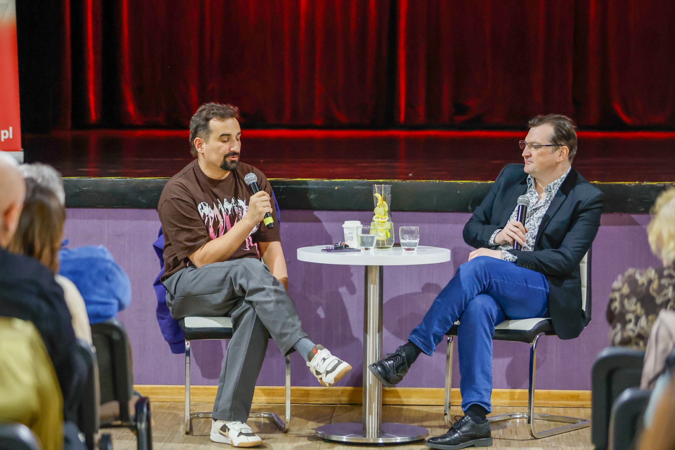 Michał Koterski w rozmowie z Marcinem Michrowskim, siedzący przy stoliku