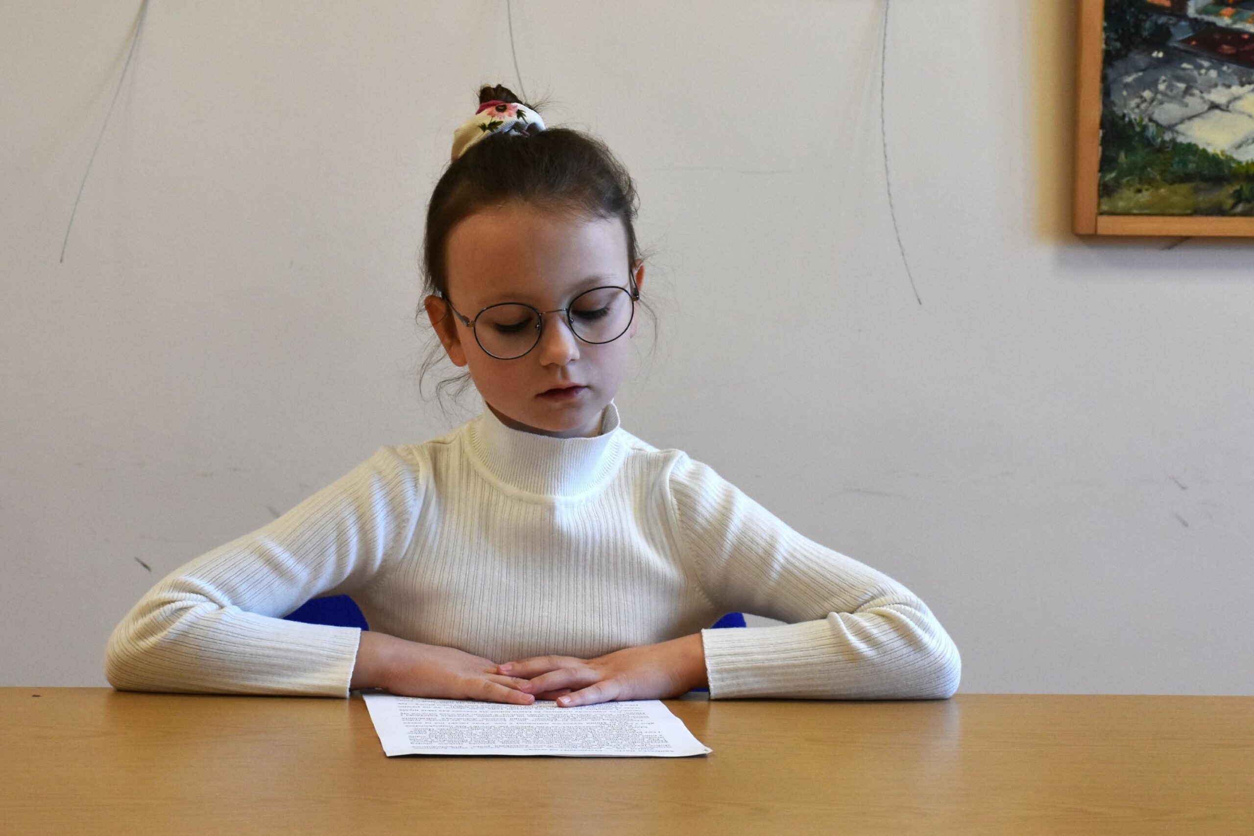 Daria czytająca przygotowany tekst siedząc przy stole