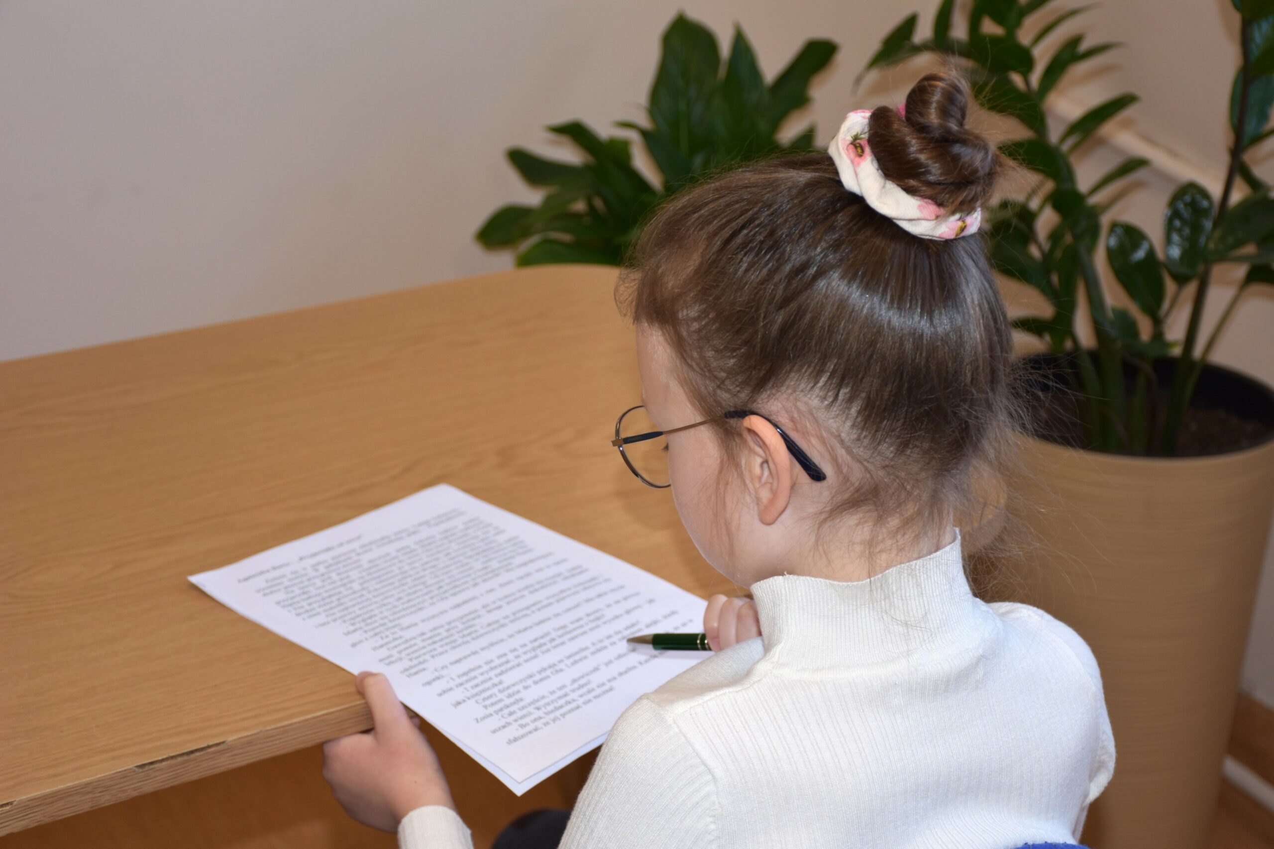 Daria rozwiązująca test siedząc przy stole