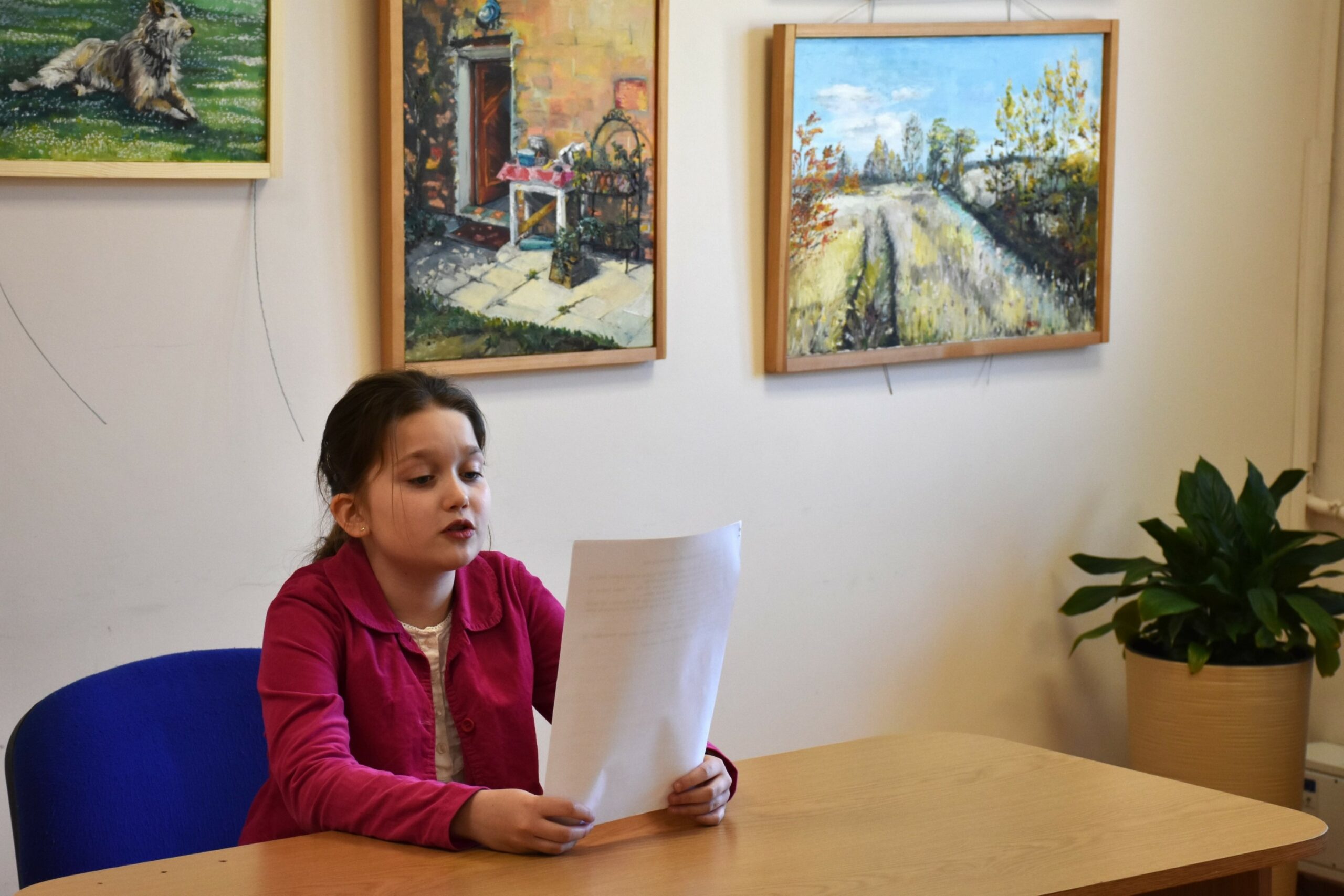 Natalia czytająca przygotowany tekst siedząc przy stole