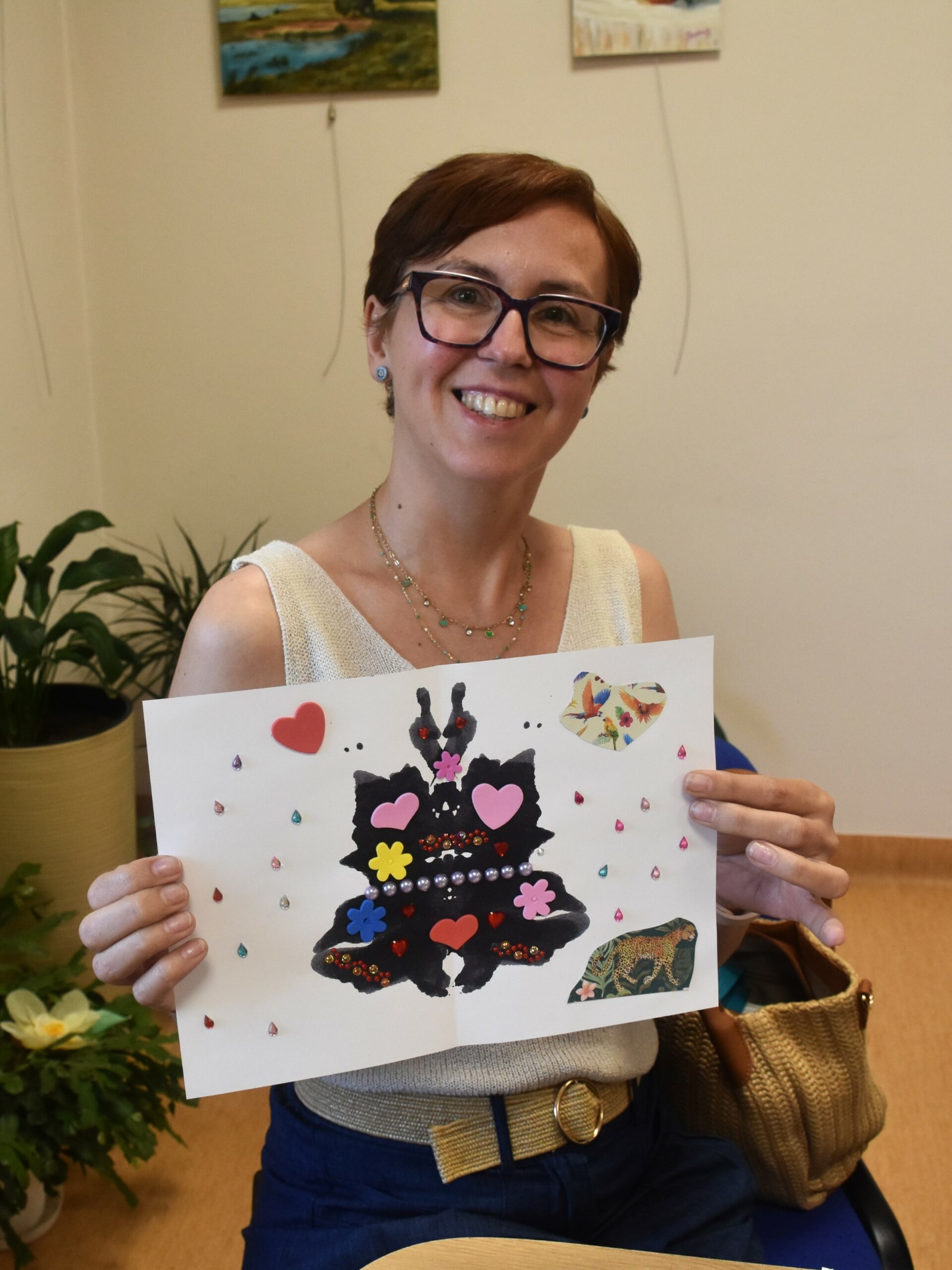 Uczestniczka warsztatu oswoić lęk prezentująca ozdobiony cekinami kleks atramentu symbolizujący strach