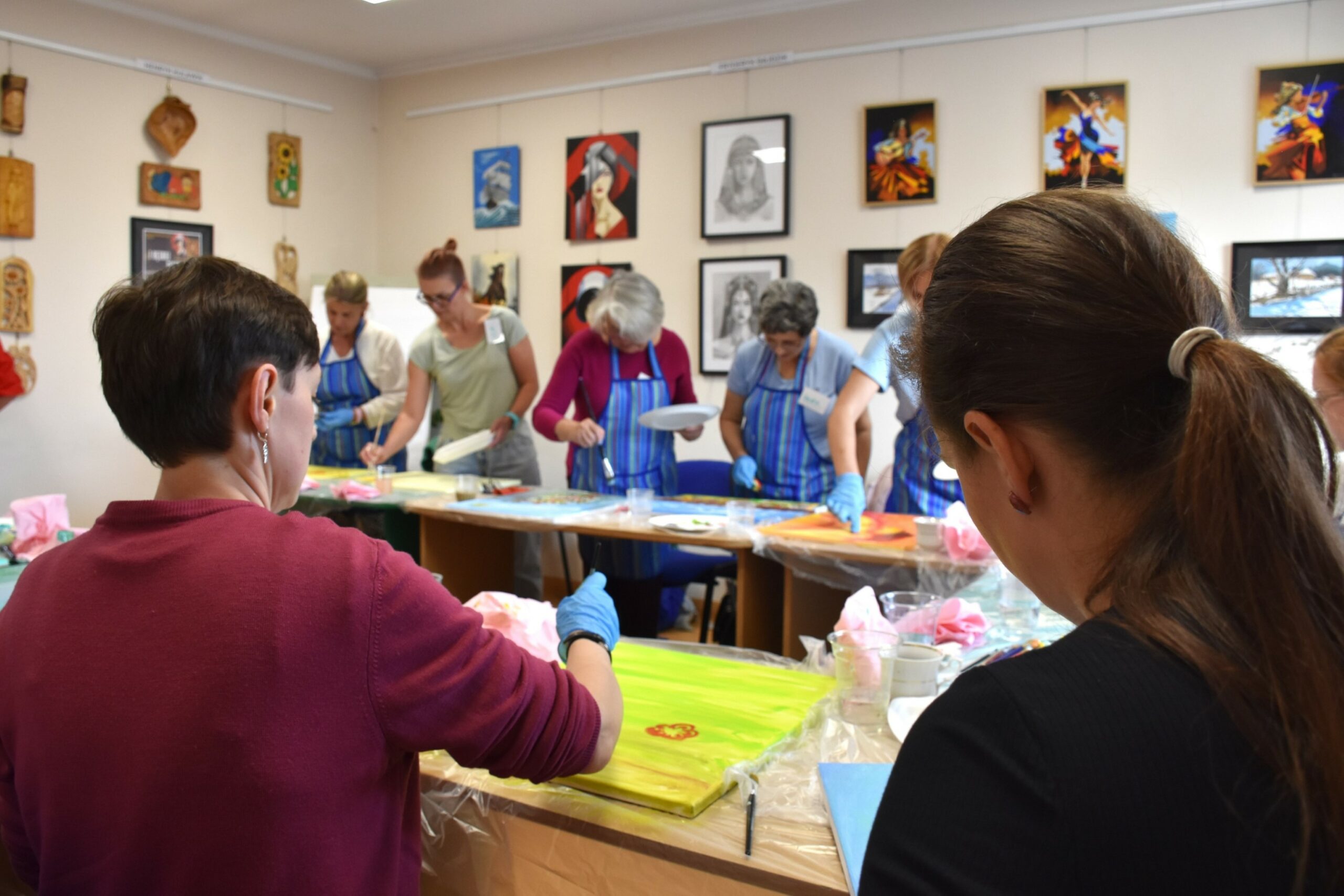 Widok na malujące na płótnach uczestniczki warsztatu paleta emocji