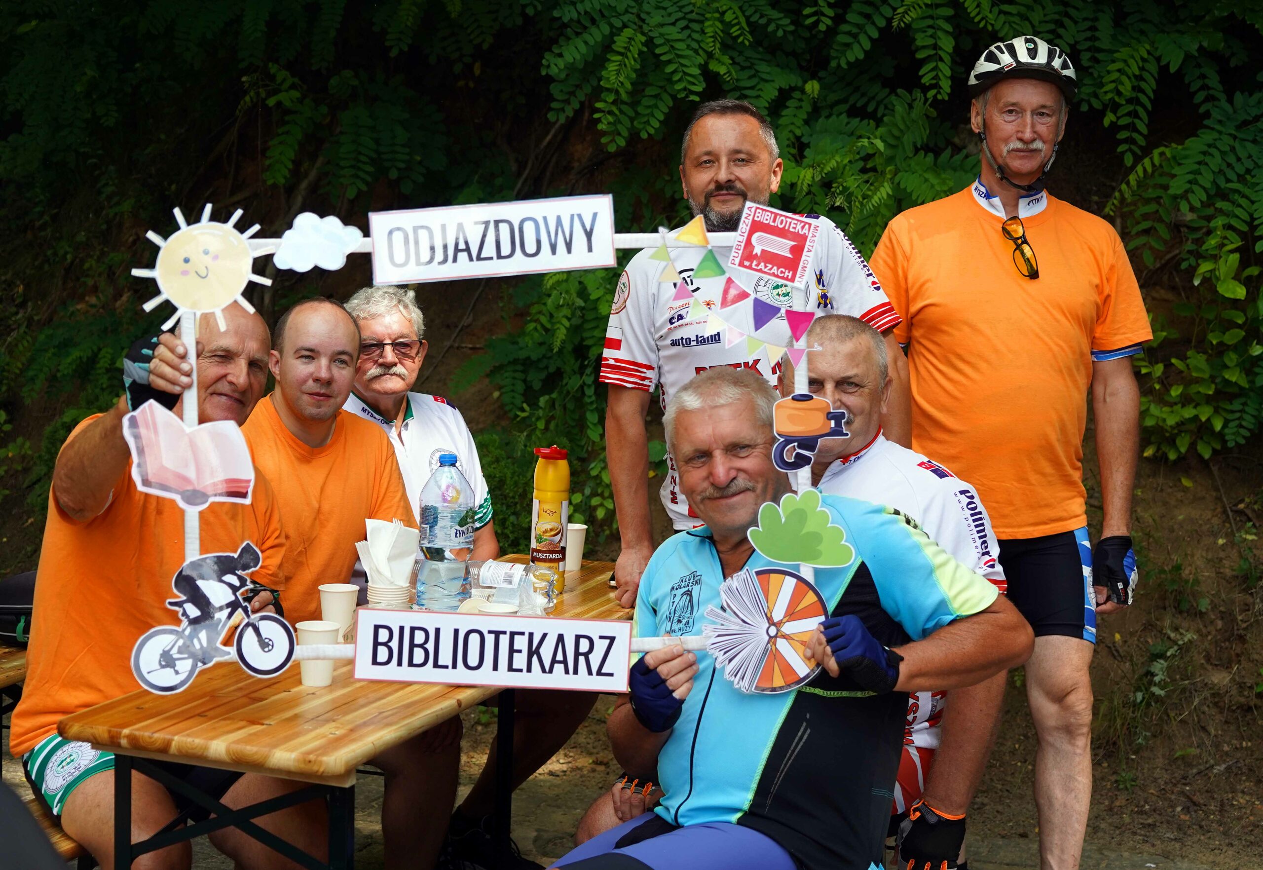 Siedmiu uczestników rajdu odjazdowy bibliotekarz 2025 pozujących w ozdobnej rajdowej ramce