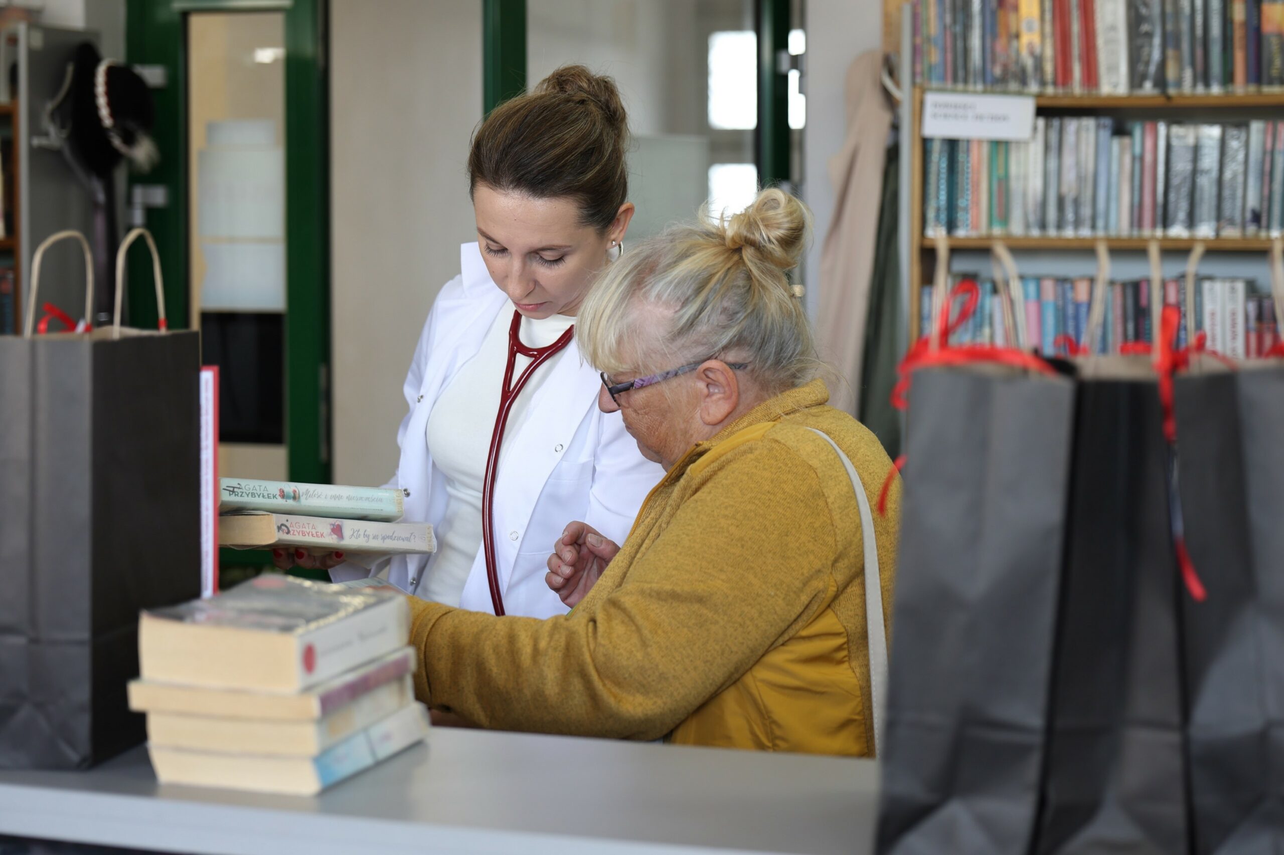 Bibliotekarka prezentująca czytelniczce ksiązki w akci literacki zestaw ratunkowy