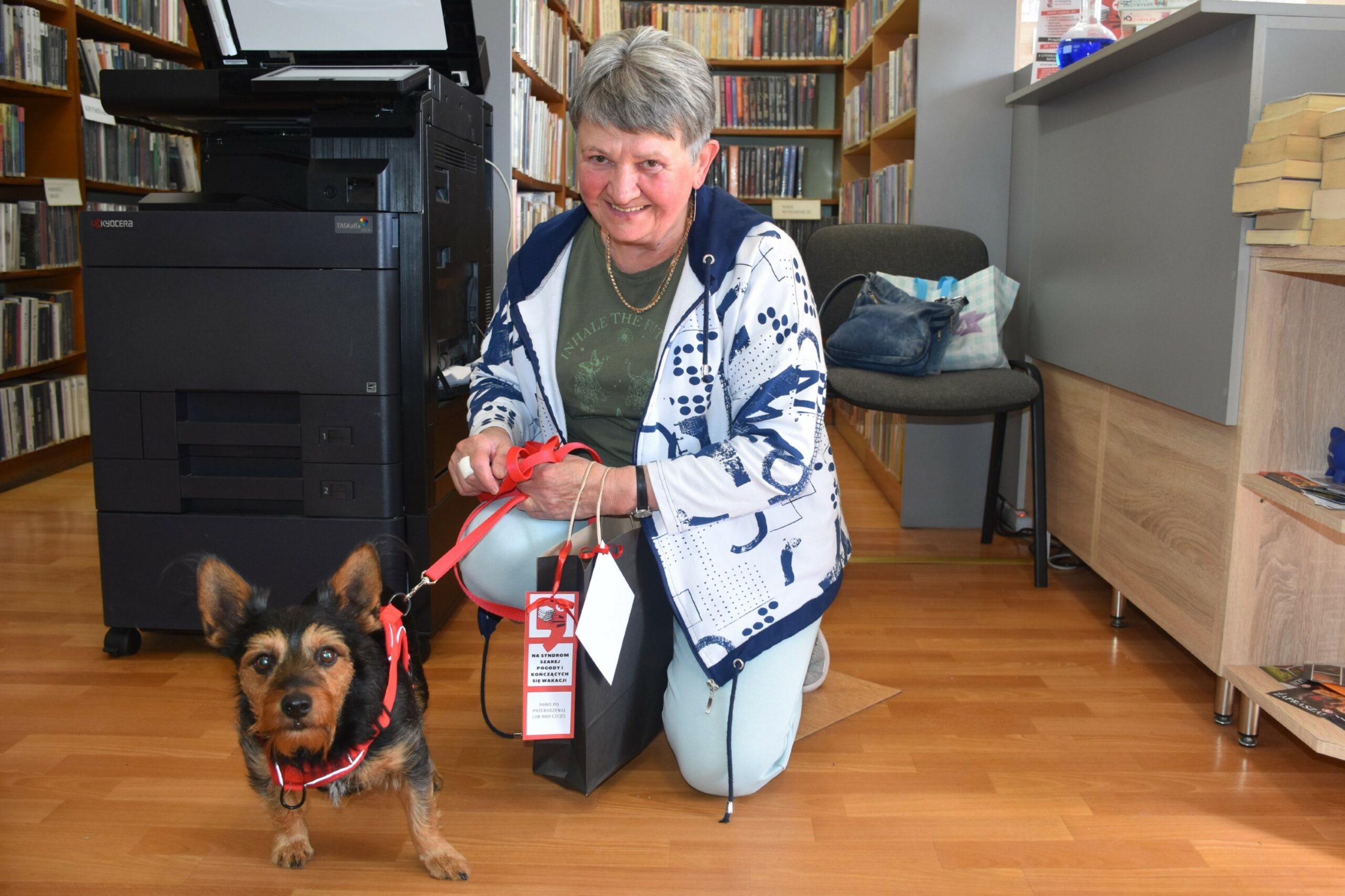 Czytelniczka z małym czarnym psem w wypożyczalni dla dorosłych