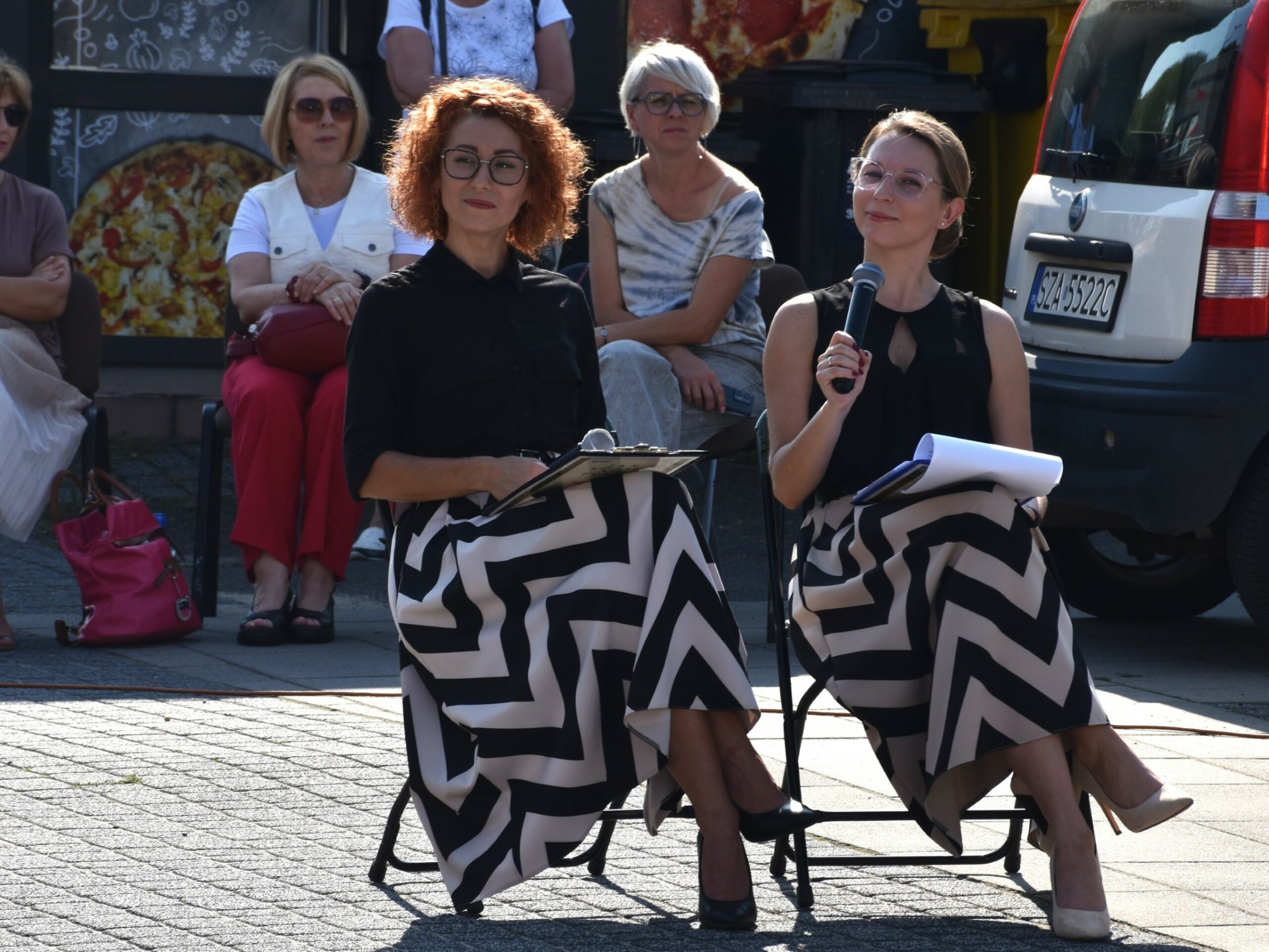 Dyrektor biblioteki i kierownik wypożyczalni - siedzą na krzesełkach z mikrofonami w ręku