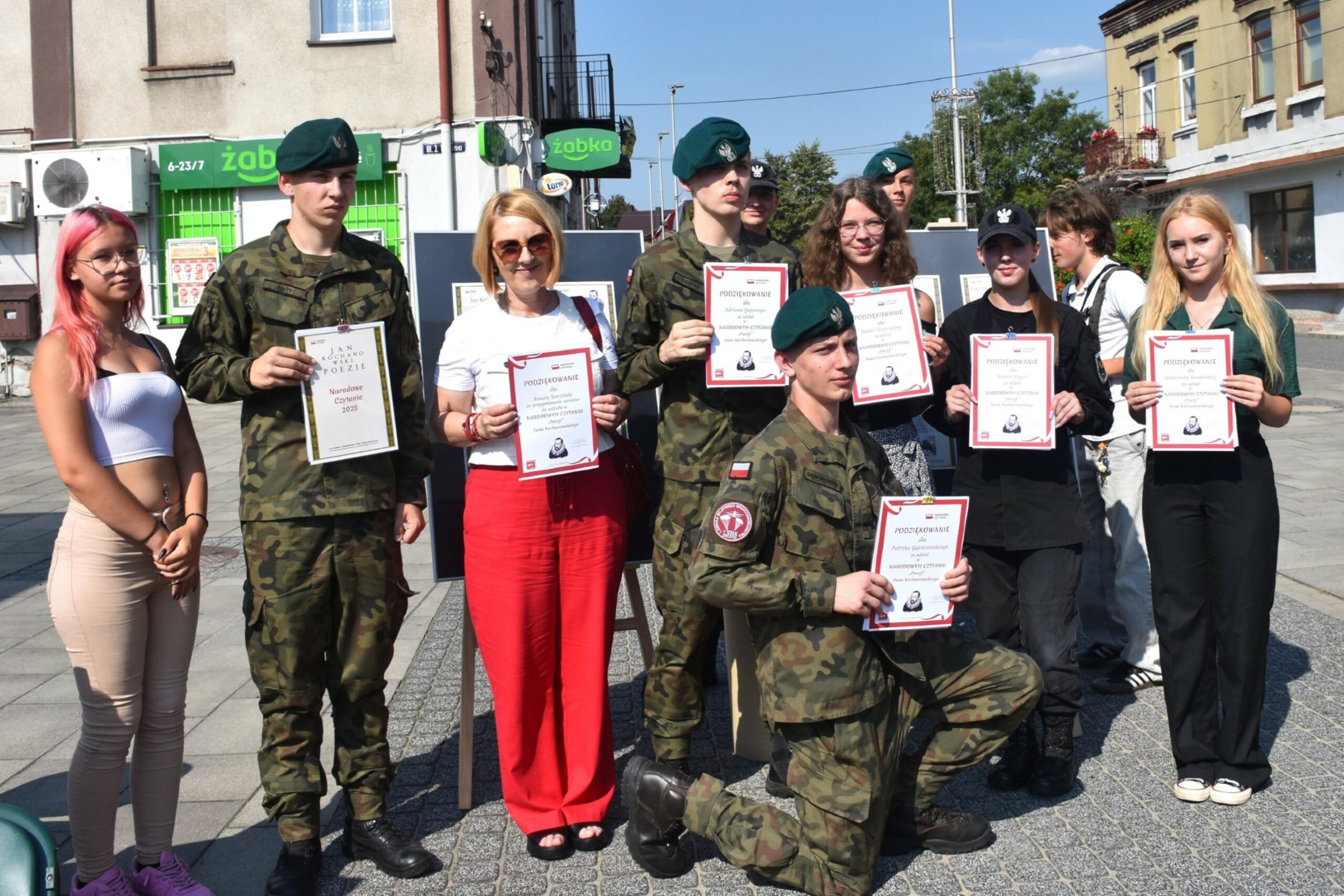 Dziesięciu licealistów i wychowaczyni na stojąco - prezentują dyplomy z narodowego czytania