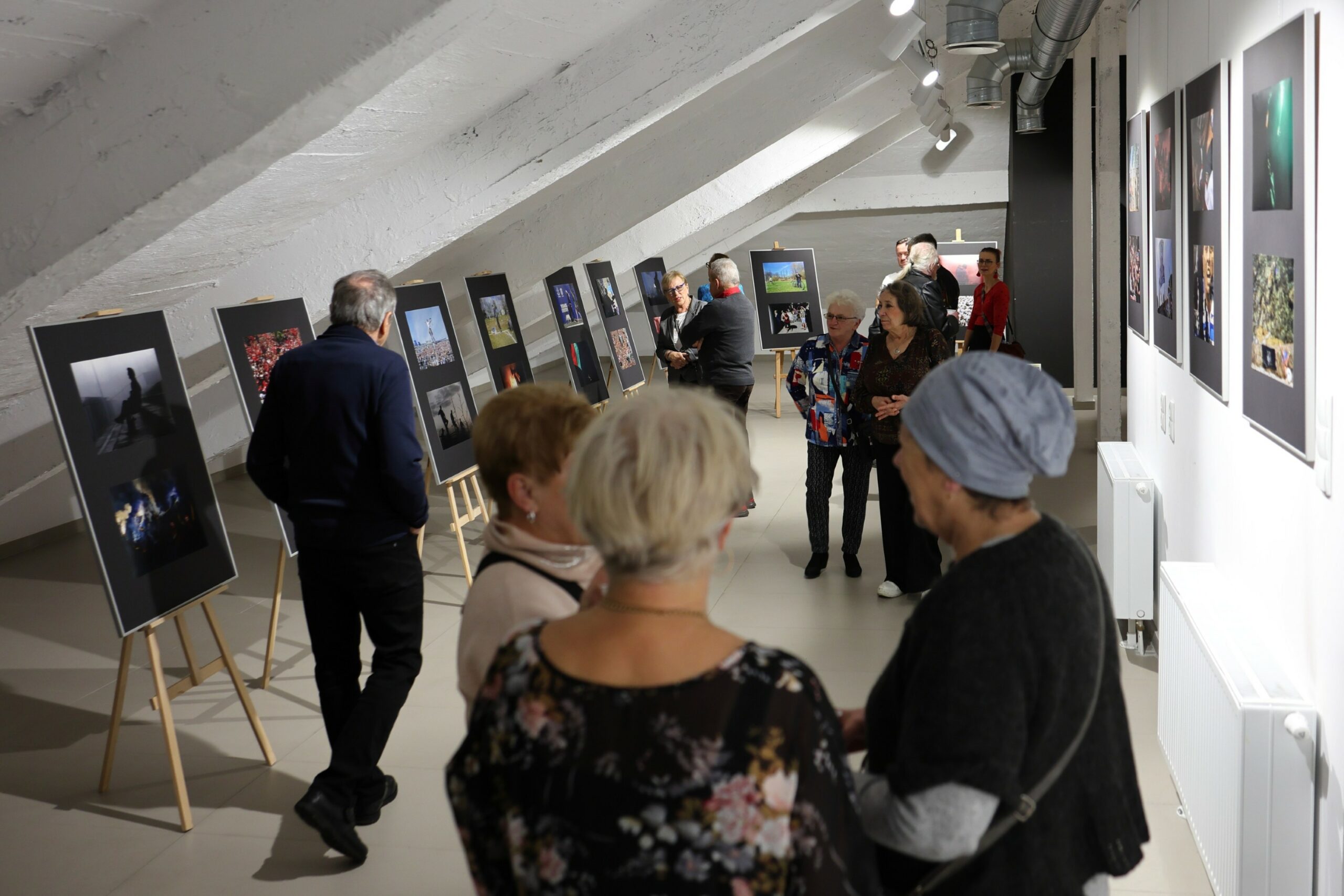 Uczestnicy wernisażu wystawy oglądający prace