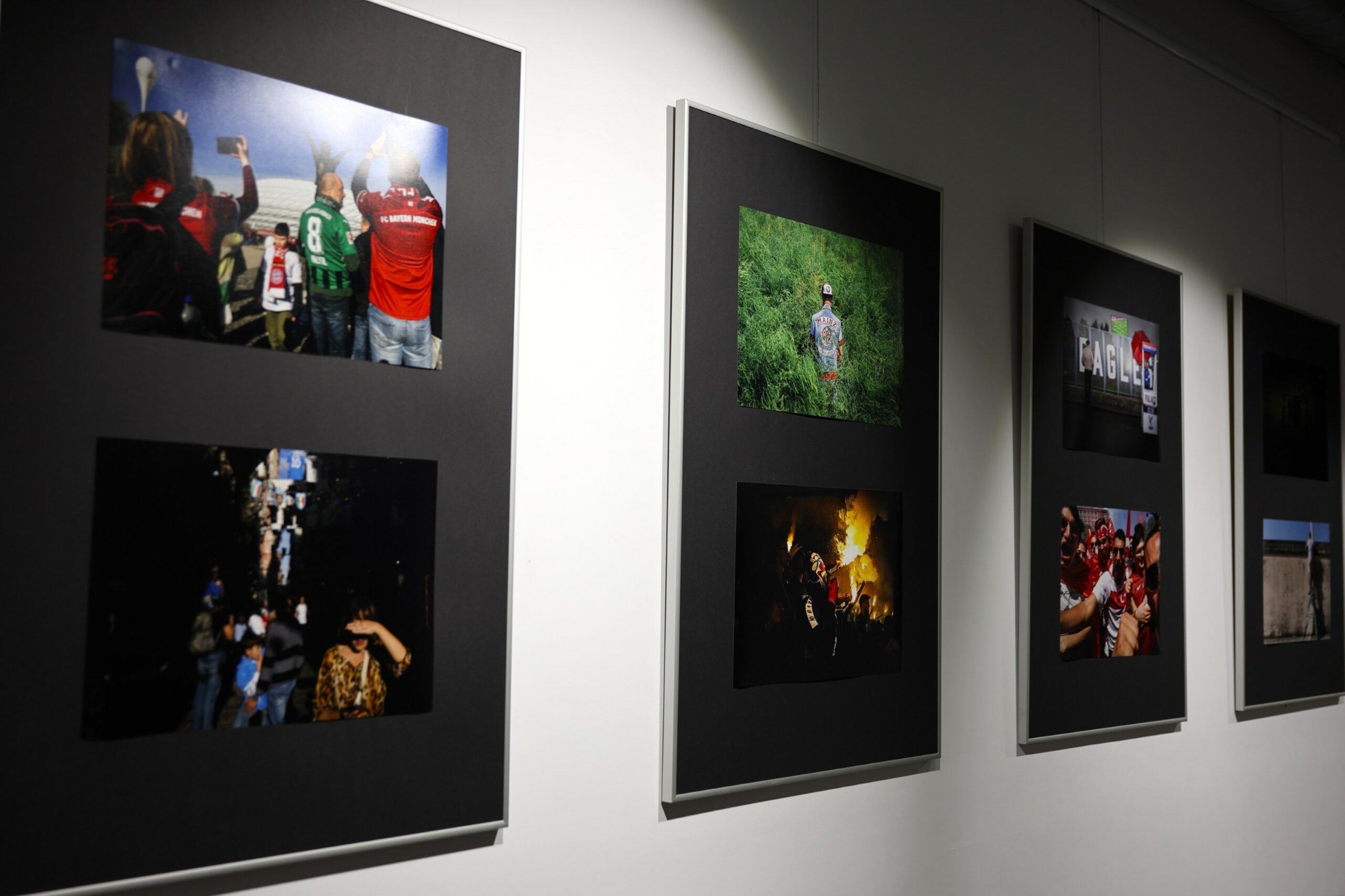 Widok ściany z czterema antyramami wypełnionymi fotografiami