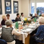 Zdjęcie grupowe - uczestniczki dyskusyjnego klubu książki siedzące przy wigilijnym stole