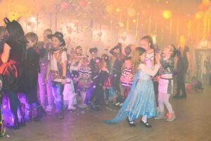 Bal karnawałowy- tańczące w przebraniach dzieci w otoczeniu baniek mydlanych
