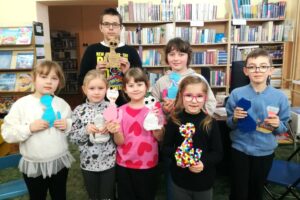 Pięć dziewczyn i dwóch chłopców prezentujących kreatywne figurki i wizerunki kotów