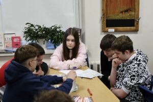 Pięcioro zamyślonych uczniów siedzących przy stole