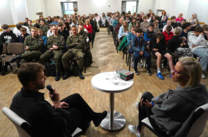 Widok na salę miejskiego ośrodka kultury, wypełnionego młodzieżą oczekującą na spotkanie autorskie