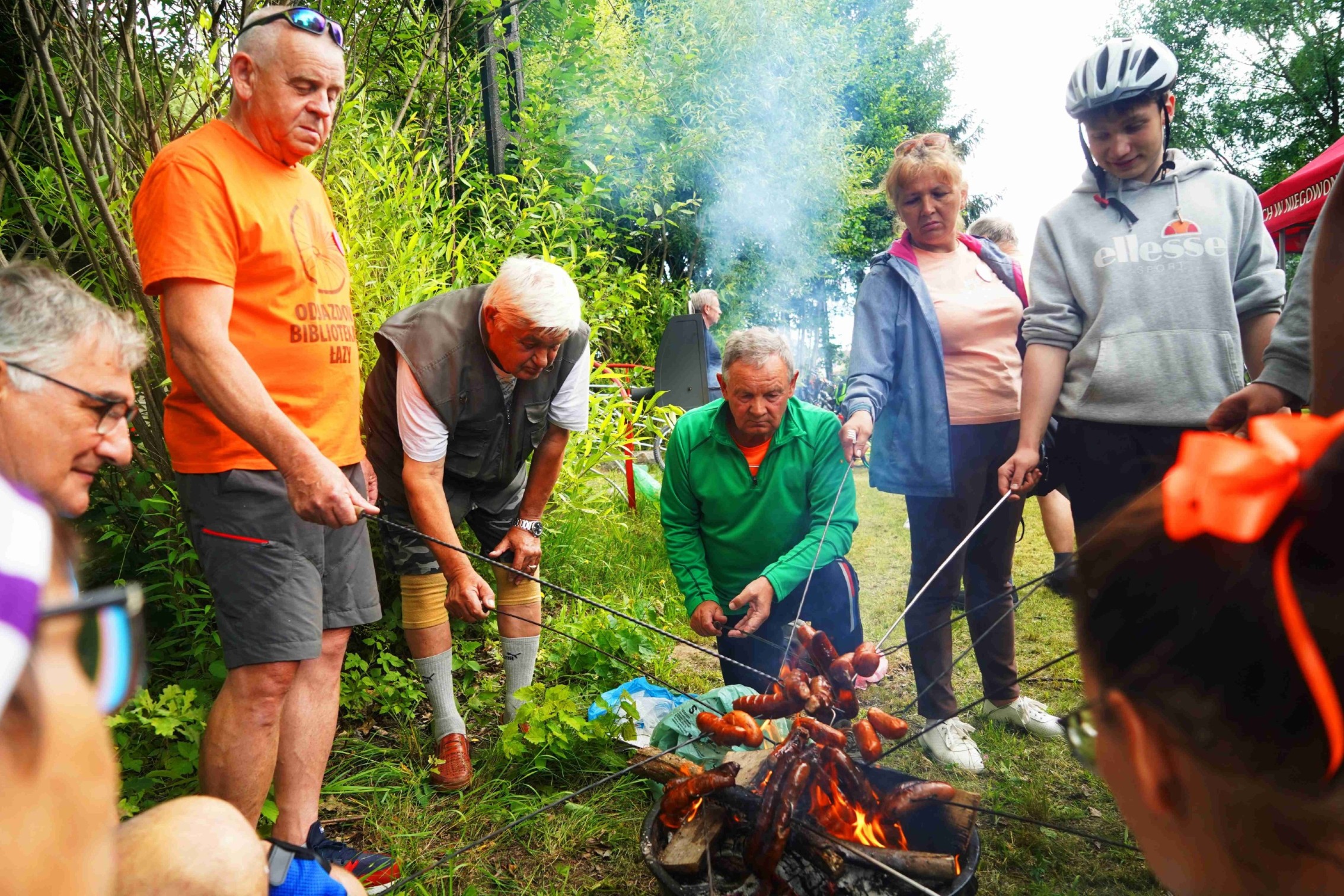 Grupa sześciu osób stojących wokół ogniska